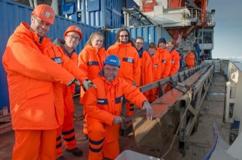 Joy at a successful extraction of a sediment core bore: Polarstern expedition leader Prof Dr Rüdiger Stein (in blue helmet) and his team posing beside the gravity corer containing the sediment core. (Photo: Alfred Wegener Institute / Audun Tholfsen, UoB)