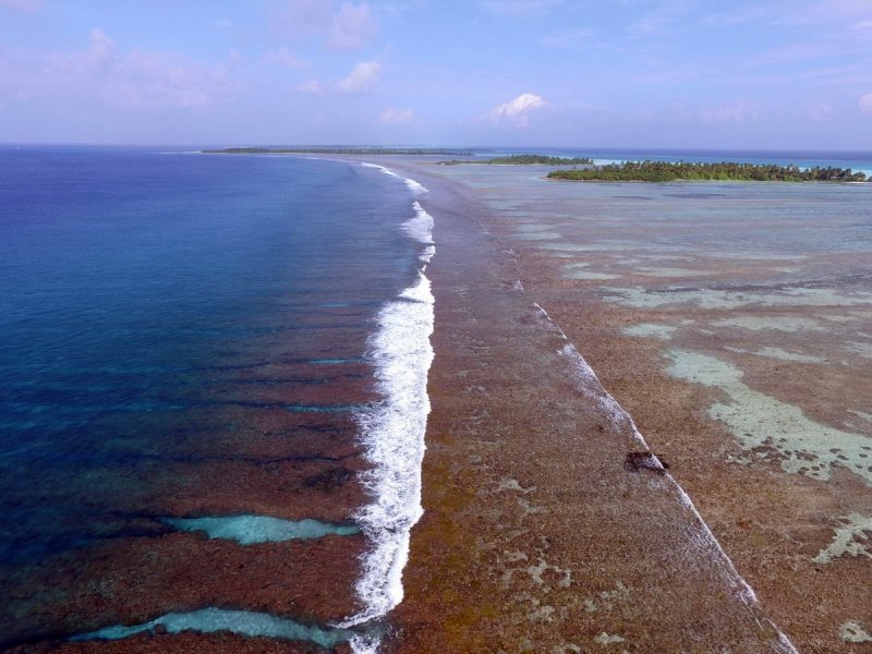 Waves breaking across a reef flat in the southern Maldives. These shallow water reef zones absorb large amounts of wave energy creating lower energy conditions behind.
(c) Prof Chris Perry, University of Exeter