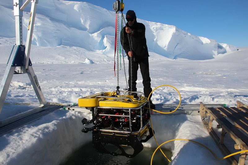 AWI biologist Horst Bornemann heaves the diving robot out of the hole in the ice with the aid of a beam construction (c) Dominik Nachtsheim