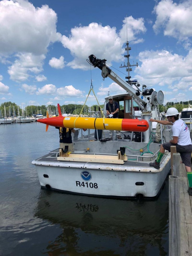 Researchers hoist a long-range AUV onto a NOAA research vessel that will carry it out into the open waters of Lake Erie. (c) NOAA.