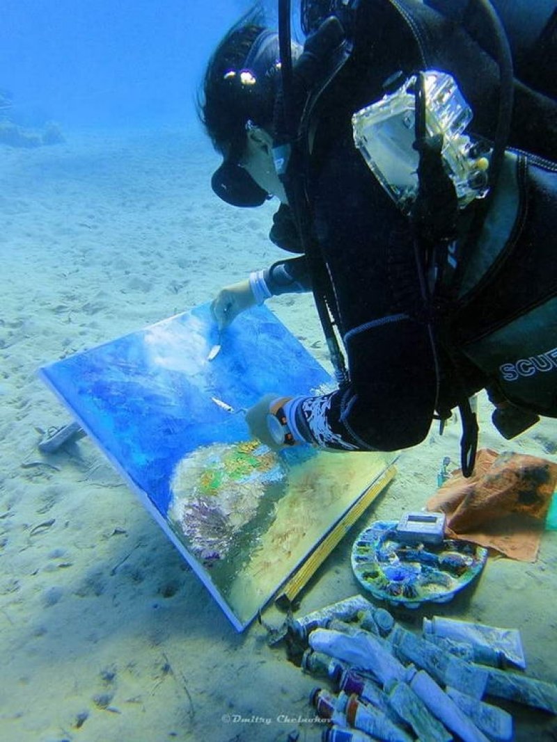 Olga works on the canvas under water
