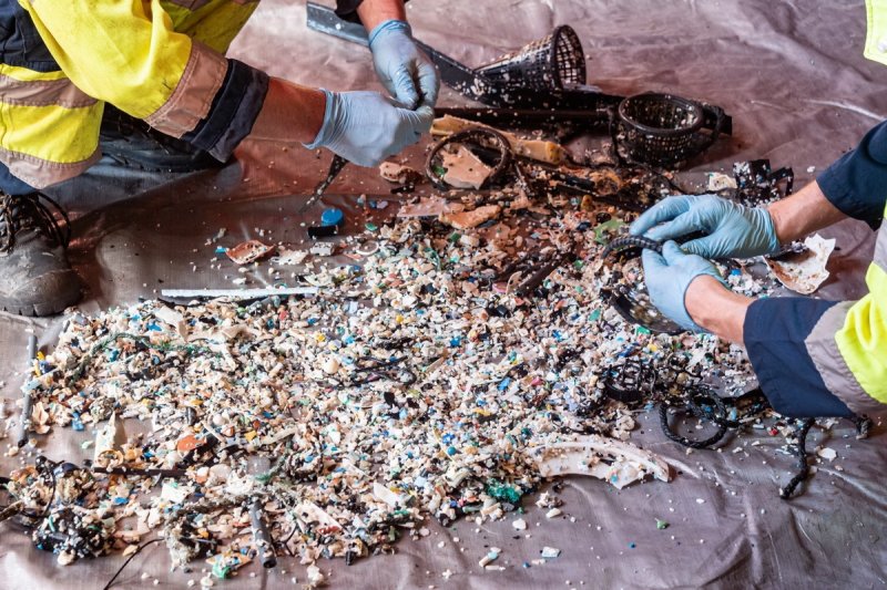 Crew sorting plastic into size and type classes onboard the support vessel during System 001/B mission (c) Aerial View (c) The Ocean Cleanup