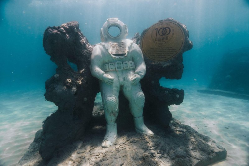 Underwater art installation at Guardians of the Reef surrounded by reef life