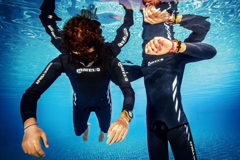 Freediver practicing no-fins freediving with a qualified buddy in a pool