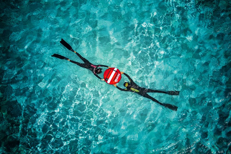 Freedivers training at a buoy in the ocean