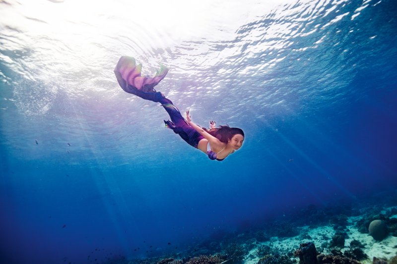 Professional mermaid diving in the ocean