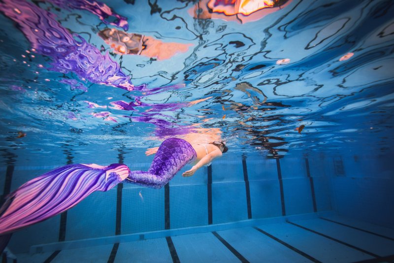 Teen participant learning how to swim with a mermaid tail during SSI Mermaid training